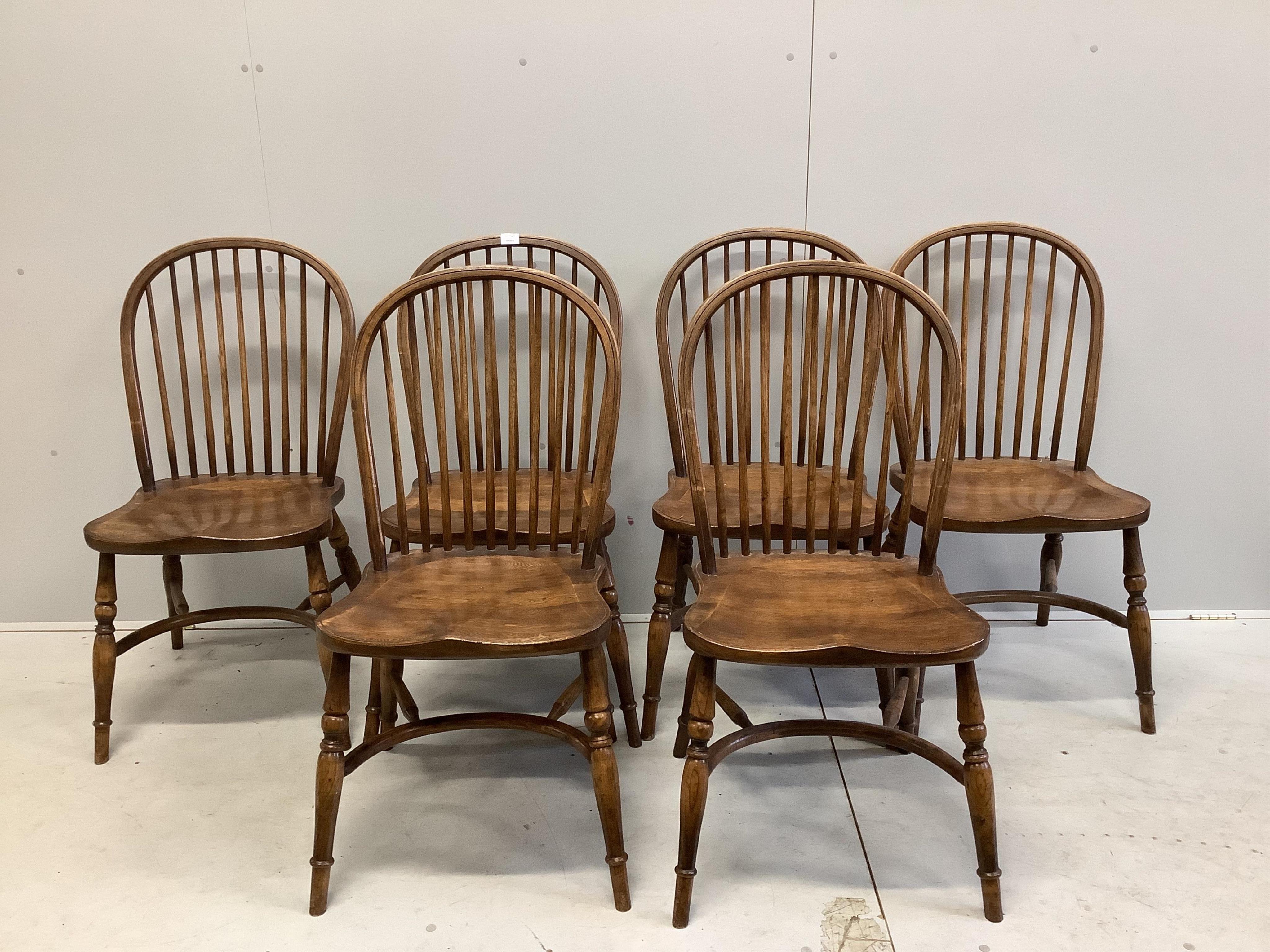 A set of six oak Windsor comb back dining chairs with crinoline stretchers, width 48cm, depth 43cm, height 94cm. Condition - fair to good